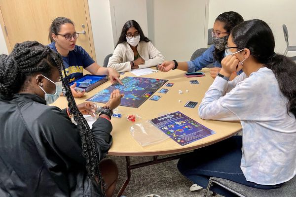 Campers play the board game Pandemic.