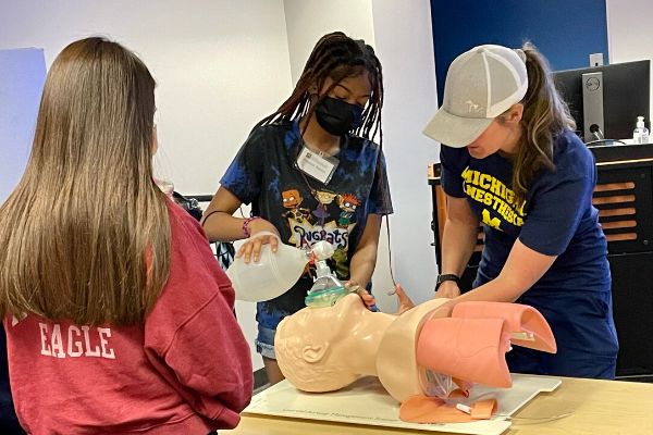 Campers work with a mannequin in the nurse anesthesia classroom.