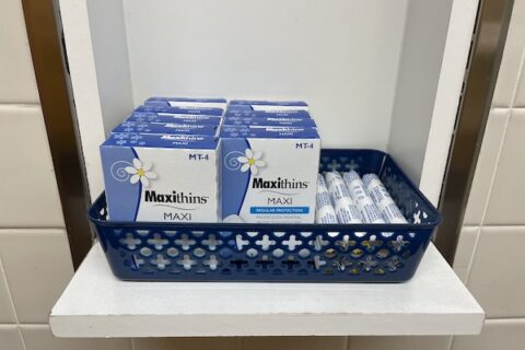 A basket of menstrual products in a bathroom.