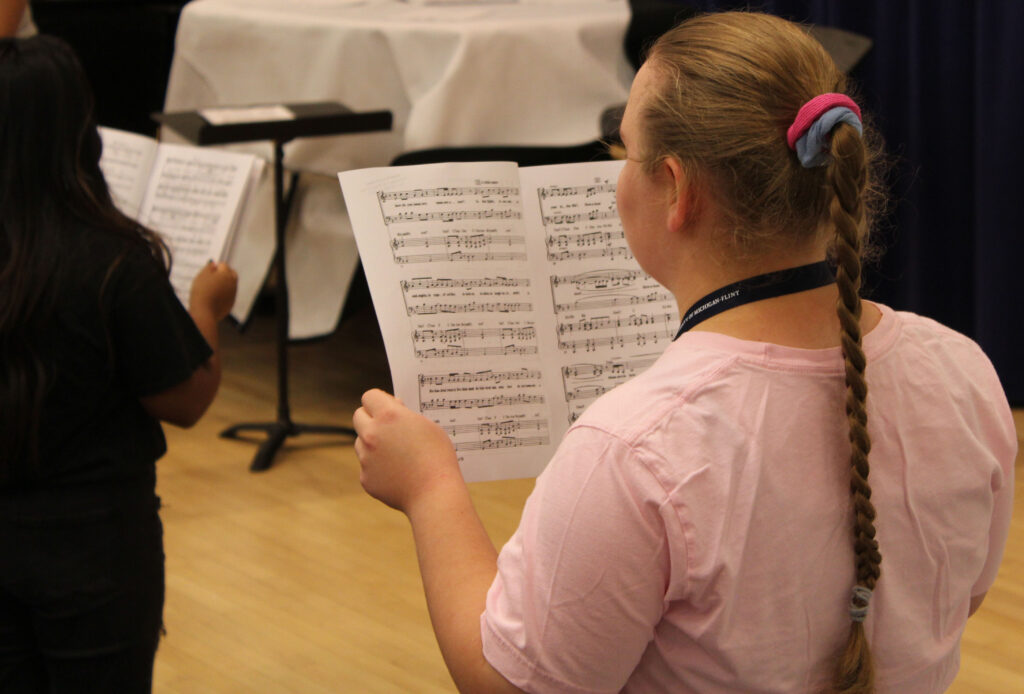 student refers to their sheet music during the Summer Vocal Academy program