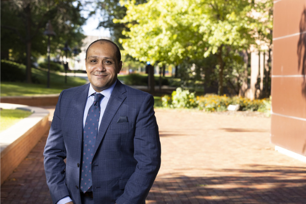 Yasser Aboelkassem wearing a suit posing outside on campus