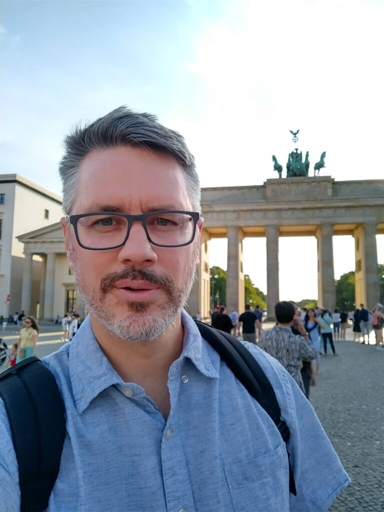 Christopher Molnar, Wyatt fellow and UM-Flint associate professor of history, poses in front of the Brandenberg Gate in Berlin