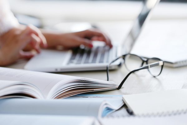 A woman working on a laptop at a desk