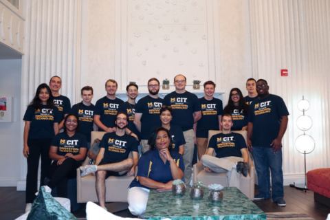 A group of students and professor Shirl Donaldson posing for a photo in UM-Flint CIT shirts