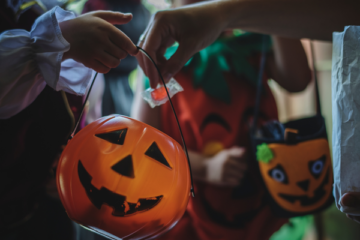 a close up of trick or treaters getting candy