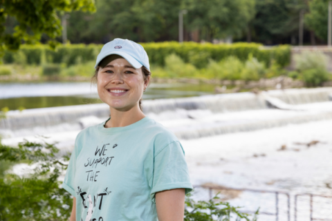 Chloe Summers smiles for a portrait in front of the Flint River, with the Flint River inthe background