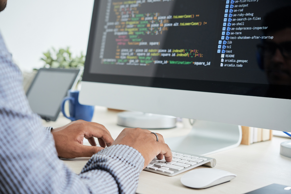 A close up of a man coding on a computer.