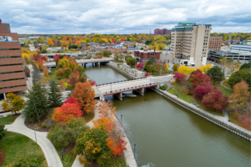 an aerial view of the flint river as it flows through the UM-Flint campus with fall colors