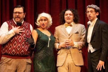 Four students in 1930s era costumes performing on stage.