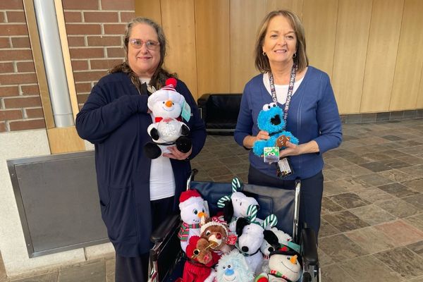 Occupational therapy assistant professor Donna Case (left) presented Rhonda Mattiuzzo, an occupational therapist with the Genesee Intermediate School District, with adapted toys for use by the GISD's early intervention program.