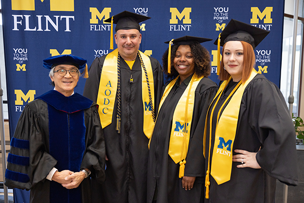 AODC Program Director Roy Barnes (far left) stands with program graduates Michael Bernal, D'Mya Mason and Alizia Hamilton.