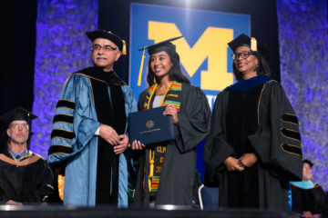 A student receiving her diploma on stage