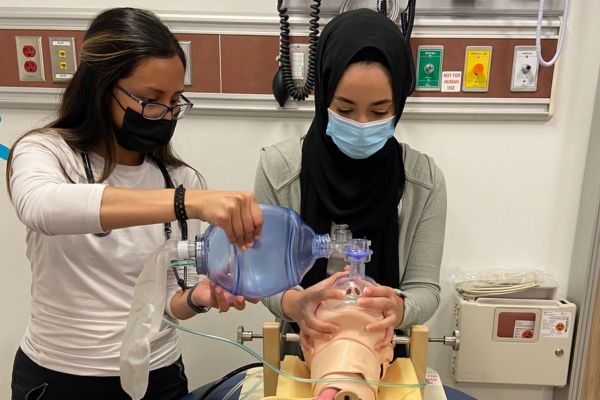 Laura Barrientos and Noor Alsaleh complete a lab during the PA program.