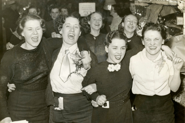 A black and white photo of women in a crowd.