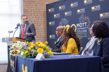 A student speaking at a podium at the press conference.