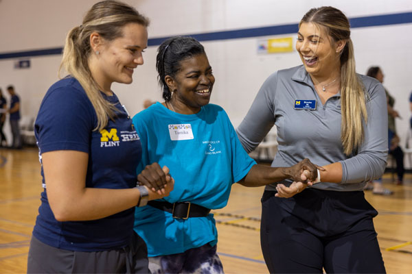 Olivia Roe and Brooke Mazzolini work with a patient at UM-Flint's pro-bono health clinic, HEART.