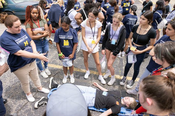 Campers listen to physician assistant clinical assistant professor Sara Guerin during the accident simulation