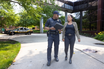 A police officer walking with a woman on campus