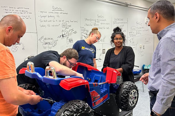 Christopher Williams, Matt Roome, Elizabeth Mansfield, Shalini Augenstein and assistant professor Thiago Ferreira work on the car.