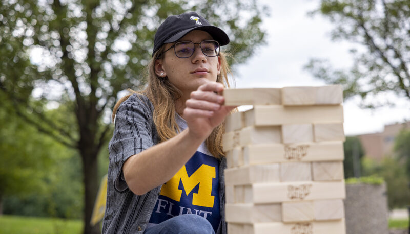 A student playing big Jenga outside