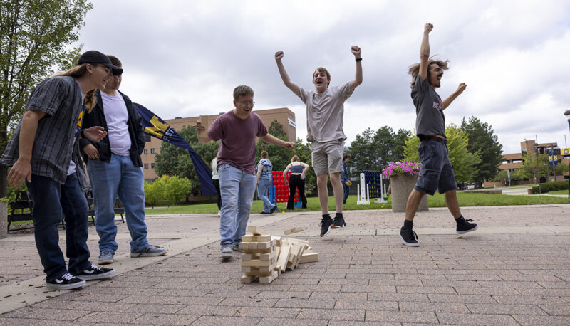 Students celebrating a win after the Jenga tower fell