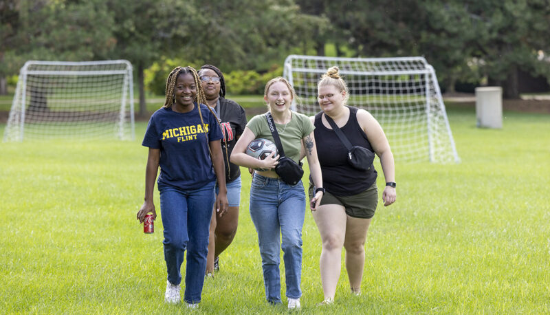 A group of students walking on a soccer field