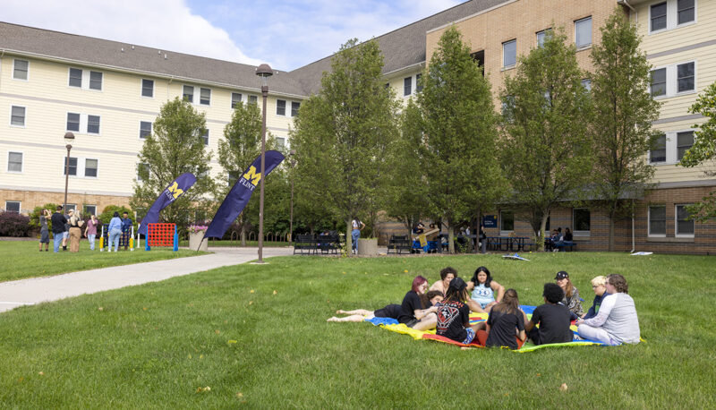 Students sitting on the First Street Residence Hall Lawn