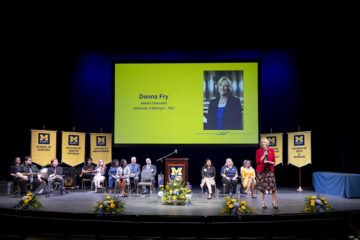 A shot of the Academic Convocation Stage with Interim Chancellor Donna Fry speaking.