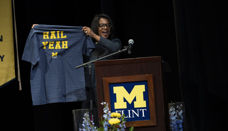 Sonja Feist Price holding up a hail yeah t shirt on stge