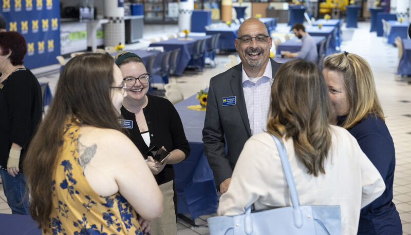 A group of staff talking at the Welcome Back BBQ