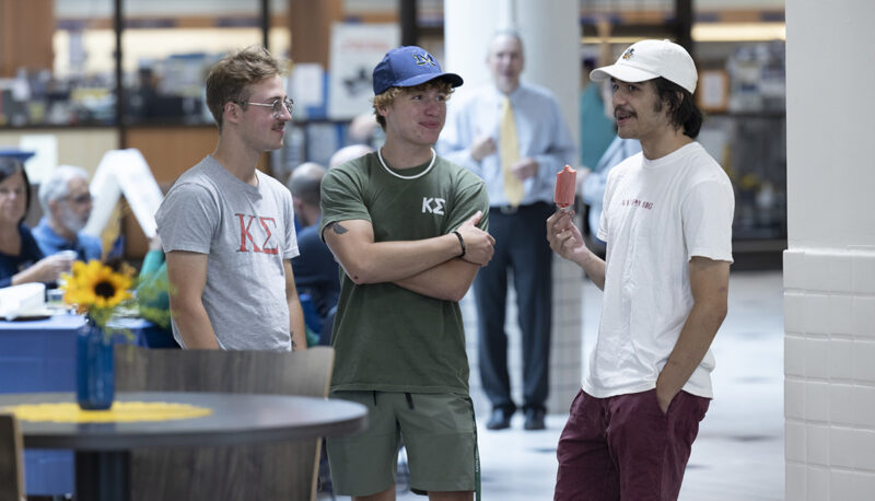 Three students standing and talking at the Welcome Back BBQ