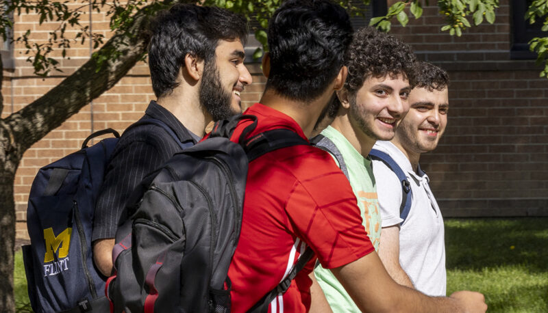 A group of students walking and talking outside on campus