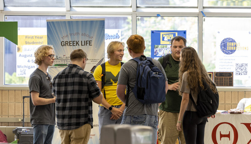 A group of students standing and talking in the UCEN