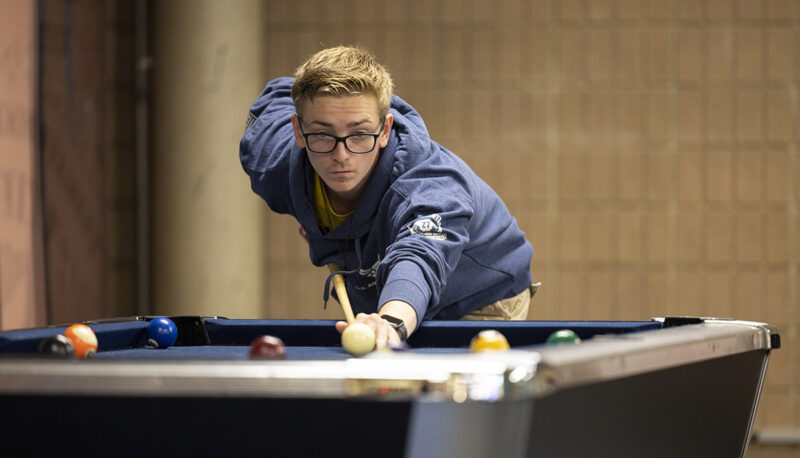 A student shooting pool