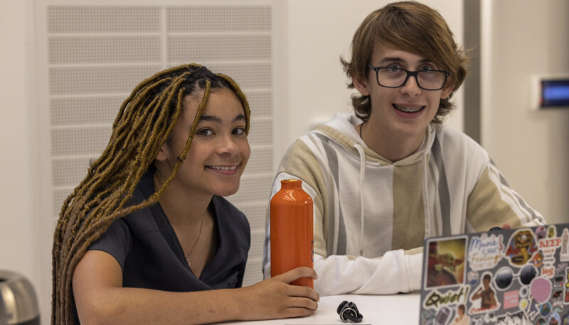 Two students sitting and smiling