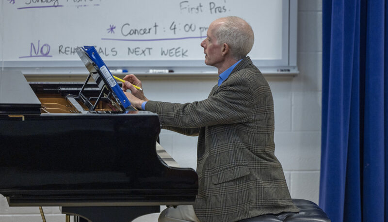 A music professor sititng at a piano