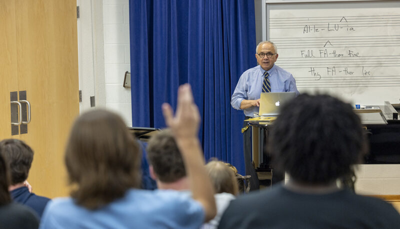 A view of a student raising his hand in class