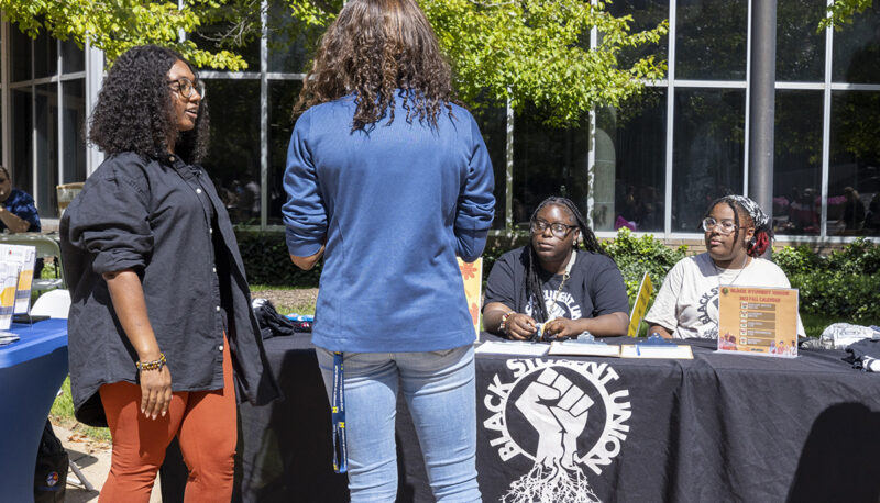 People talking in front of the Black Student Union table