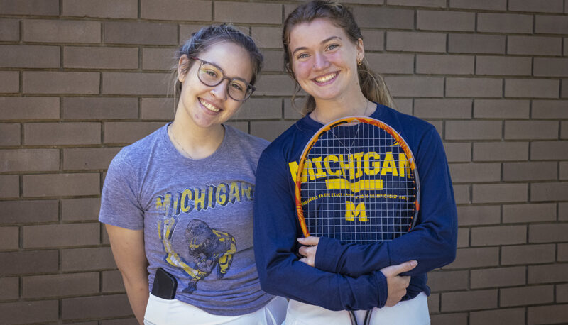 Two students posing with tennis rackets during Mgagement