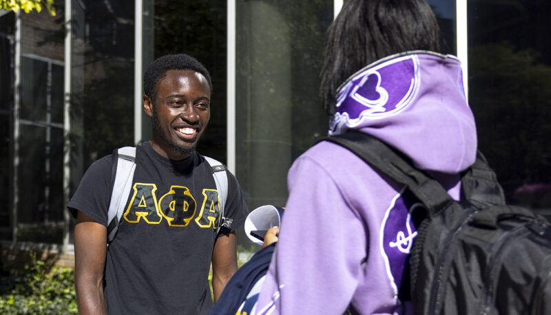 Two students talking outside during Mgagement