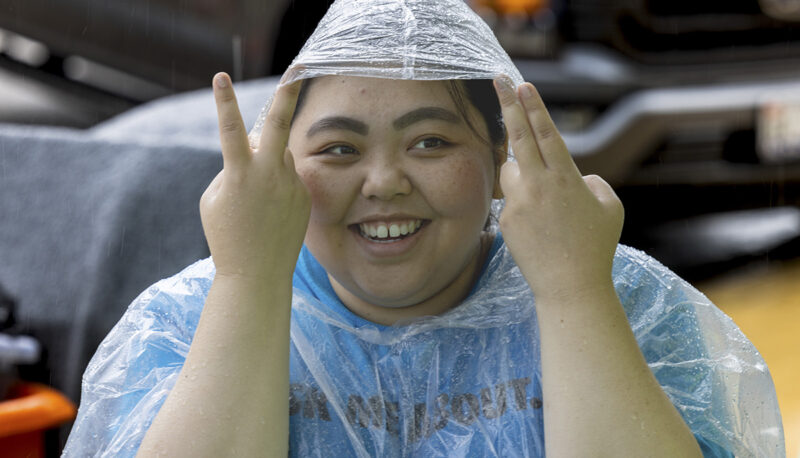 A student wearing a rain poncho outside