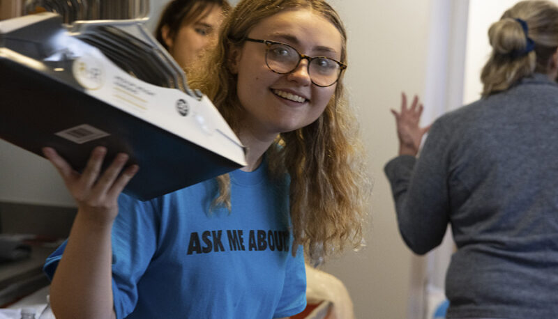 A student putting items away in a dorm room