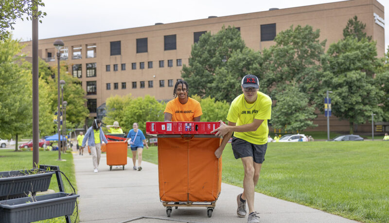 Two students pulling items into First Street Resdience hall