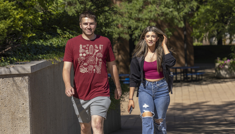 Two students walking outside on campus