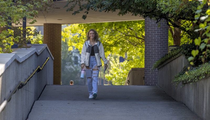 A student walking outside on campus