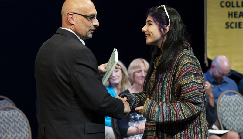 A student shaking hands with Chris Giordano on stage.