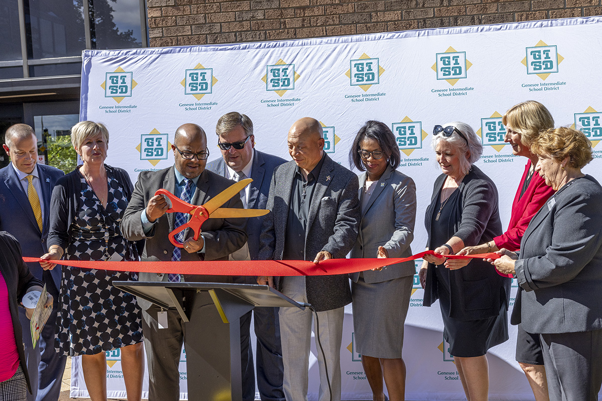 A group of people preparing to cut a ribbon