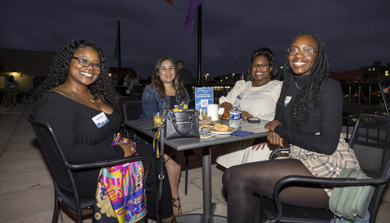 A table of alumni smiling for the camera