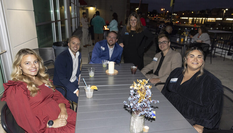 A table of alumni smiling for the camera