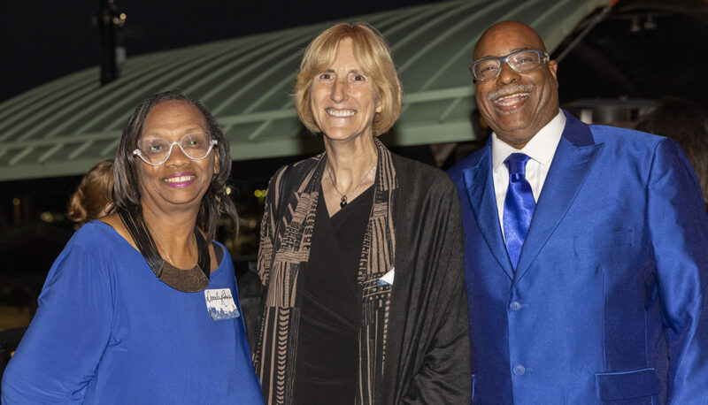 Interim Dean Donna Fry posing with two alumni